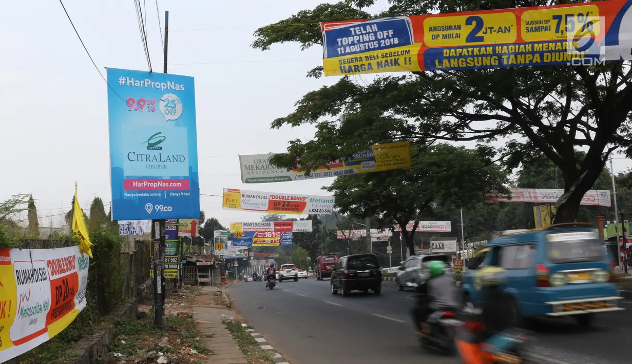 Kendaraan melintas di bawah spanduk iklan penjualan properti yang menghiasi ruas jalan kawasan Cibubur, Jakarta, Minggu (26/8). Keberadaan spanduk promosi perumahan yang tidak tepat juga bisa mengotori pemandangan jalan. (Liputan6.com/Immnuel Antonius)