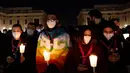 Orang-orang yang percaya memegang lilin saat berdoa untuk perdamaian Ukraina di Lapangan Santo Petrus, Vatikan, 2 Maret 2022. (Tiziana FABI/AFP)