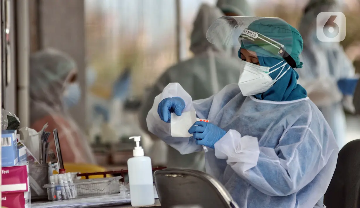 Petugas kesehatan saat melakukan swab test PCR pada warga di Laboratoriun GSI Cilandak, Jakarta Selatan, Rabu (18/8/2021). Tarif tertinggi pemeriksaan RT-PCR untuk Jawa dan Bali kini menjadi Rp 495.000, sedangkan wilayah lainnya Rp 525.000. (merdeka.com/Iqbal S. Nugroho)