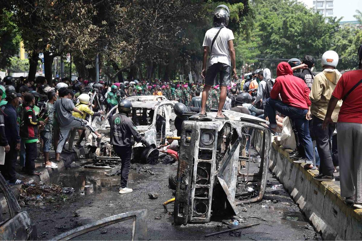 FOTO: Warga Ambil Bangkai Mobil Usai 10 Kendaraan Dibakar di Depan Mako Brimob Kwitang
