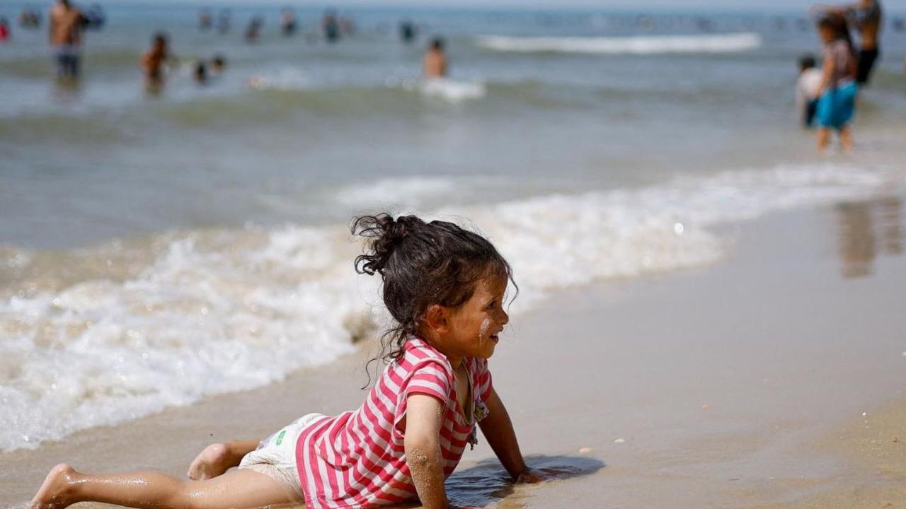Sebagian dari anak-anak terlihat bermain air di tepi pantai.<br><br>Mereka datang ke pantai untuk mengalihkan pikirannya sejenak dari kehancuran akibat perang dengan Israel. Foto: REUTERS / Mohammed Salem<br>