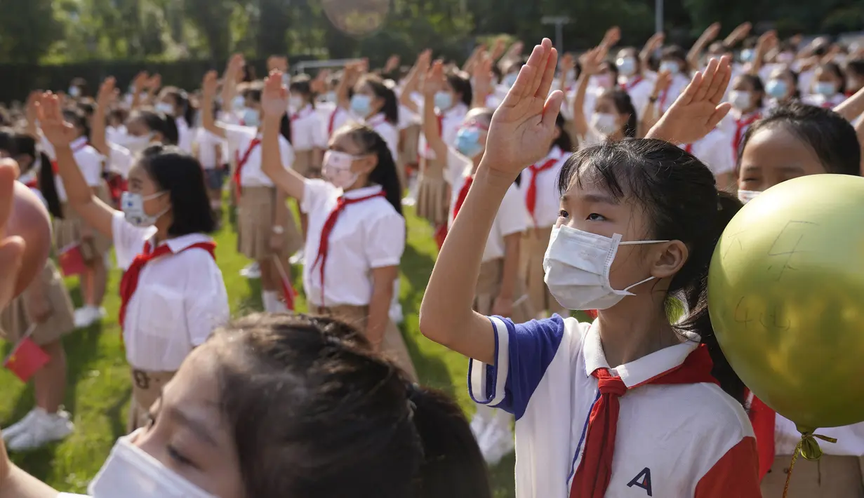 Para siswa menghadiri upacara pengibaran bendera pada hari pertama semester baru di Wuhan, Provinsi Hubei, China, 1 September 2021. Pemerintah China memutuskan pemberlakuan belajar tatap muka setelah percaya diri menangani pandemi COVID-19. (STR/AFP)