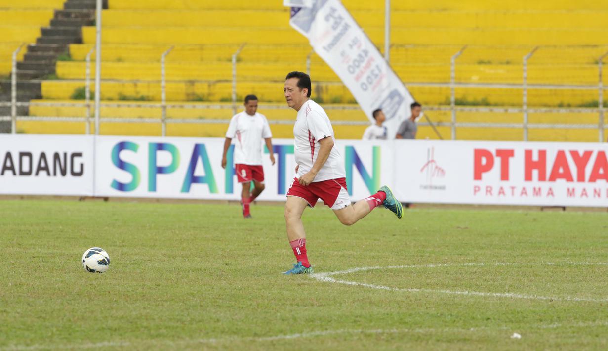 Ketua DPD RI, Irman Gusman menggiring bola saat laga Padang Allstars melawan Indonesia Allstars pada pembukaan turnamen Irman Gusman Cup 2016 U-17 dan U-19 di Stadion Agus Salim, Padang, Minggu (13/3/2016). (Bola.com/Nicklas Hanoatubun)