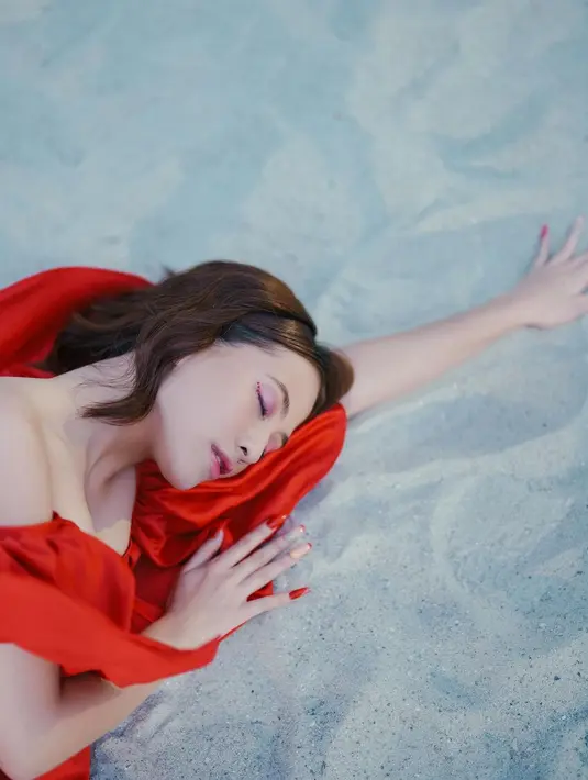 Adhisty Zara melakukan pose berbaring di pasir pantai. Posenya ini pun membuatnya tampak bak model profesional. Untuk menyempurnakan penampilannya, Zara bahkan memakai nail art yang juga bernuansa merah sesuai dengan wardrobe yang dikenakannya. (Instagram/zaraadhsty)