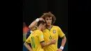 Dua pemain Timnas Brasil, David Luiz dan Oscar berpelukan usai dipermalukan Belanda 0-3 di laga perebutan tempat ketiga Piala Dunia 2014 di Stadion Nasional Brasilia, (13/7/2014). (AFP PHOTO/Vanderlei Almeida)