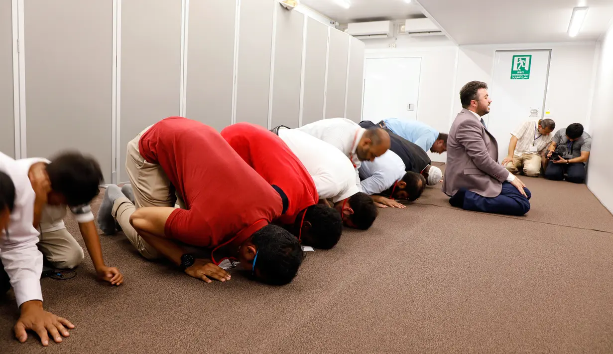 Pengunjung salat dalam truk masjid saat diresmikan di Toyota Stadium, Jepang, Senin (23/7). Truk masjid tersebut memakan biaya mencapai 1 juta yen atau sekitar Rp 130 juta. (Mobile Mosque Executive Committee via AP)
