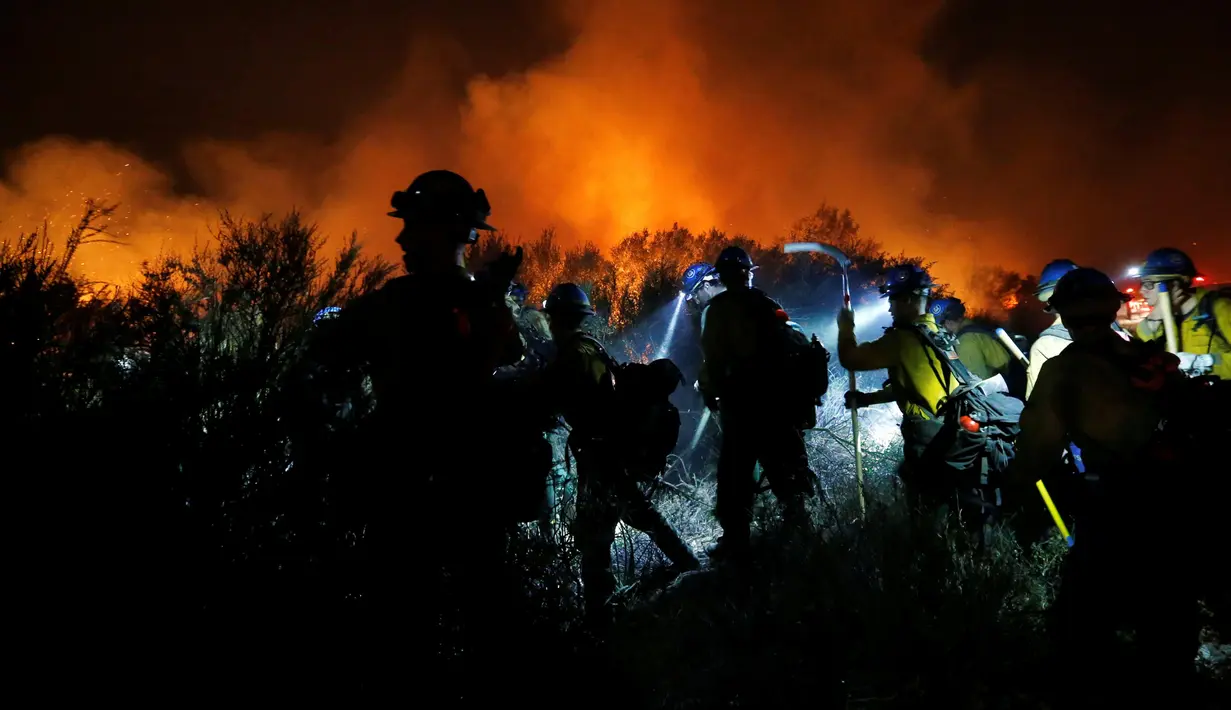 Petugas pemadam kebakaran membangun jalur api saat kebakaran hutan di California, Amerika Serikat, (17/08). Keadaan darurat sudah diberlakukan dan api sudah membakar lebih dari 7.200 hektar hutan.. (REUTERS/Patrick T Fallon)