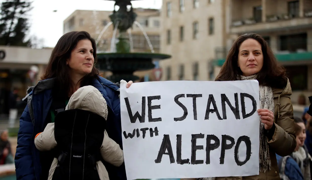 Dua warga Israel berunjuk rasa di depan kediaman Perdana Menteri Israel, Benjamin Netanyahu di Yerusalem, Jumat (16/12). Mereka mengaku prihatin dengan warga Aleppo di Suriah. (REUTERS / Baz Ratner)