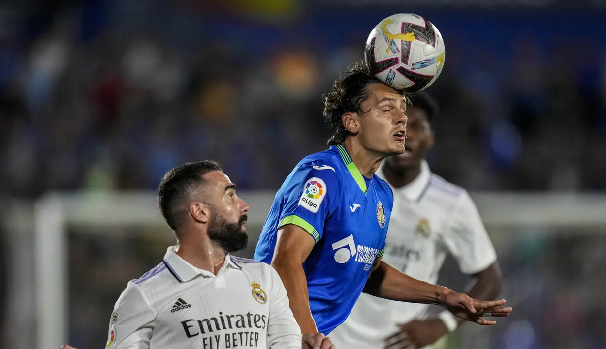 Penyerang Getafe Enes Unal berebut bola dengan bek Real Madrid Dani Carvajal pada pekan delapan La Liga musim 2022/2023 di Stadion Coliseum Alfonso Perez, Minggu (9/10/2022) dini hari WIB. Gol semata wayang Real Madrid dicetak bek tengah, Eder Militao.(AP Photo/Bernat Armangue)