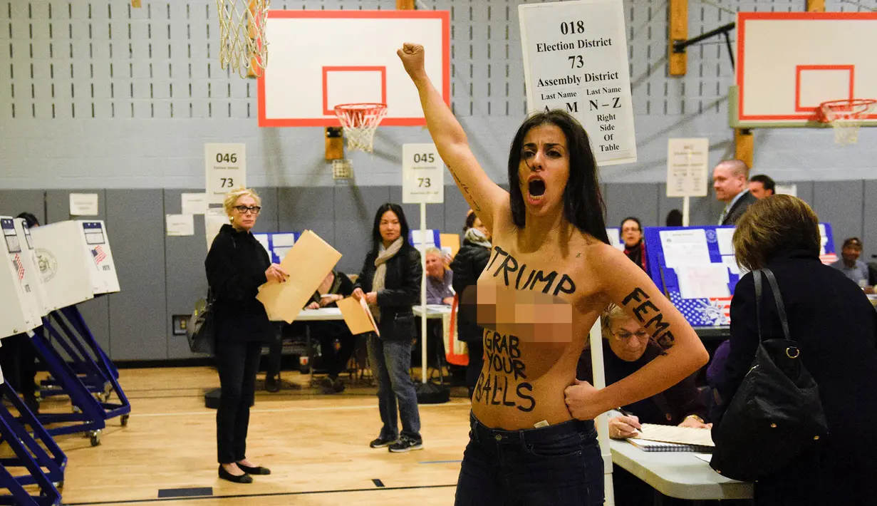 Seorang wanita bertelanjang dada melakukan demonstrasi di TPS Pilpres AS 59, di mana Donald Trump memberikan suaranya di New York, Selasa (8/11). Wanita setengah bugil itu diduga berasal dari kelompok aktivis feminis garis keras. (REUTERS/Darren Ornitz)