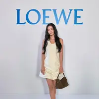 Aktris asal Korea Selatan Kim Yoo-jung mencuri perhatian lewat tampilannya yang feminin sekaligus modern. Ia mengenakan mini dress putih dengan siluet sederhana namun berkelas, dipadukan dengan Puzzle Bag berwarna cokelat,  salah satu ikon Loewe yang langsung menambah kesan timeless pada keseluruhan look-nya.
