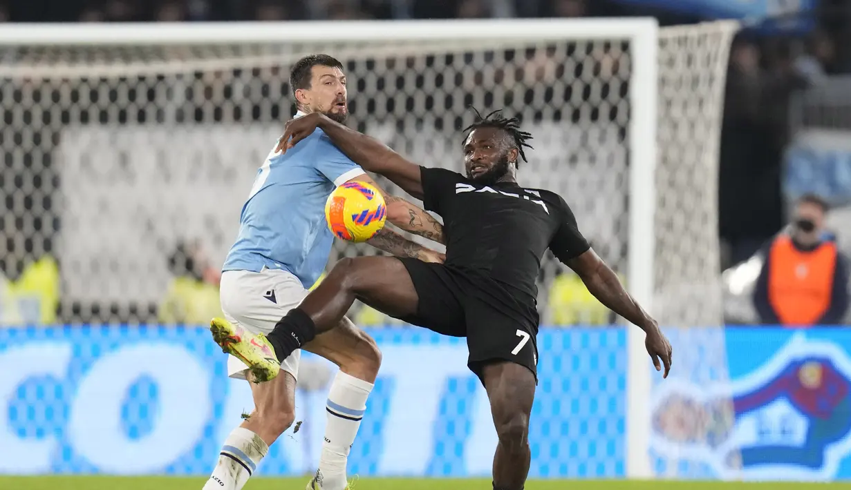 Bek Lazio Francesco Acerbi berebut bola dengan penyerang Udinese Isaac Success pada pekan ke-15 Liga Italia di Olimpico Stadium, Jumat (3/12/2021). Lazio harus puas berbagi poin setelah ditahan imbang Udinese 4-4. (AP Photo/Gregorio Borgia)