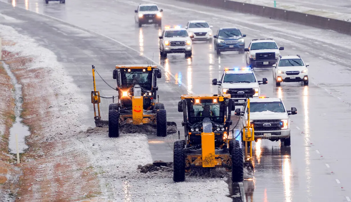 Petugas membersihkan es dari Bush Turnpike dekat Preston Road di Plano, Texas, Amerika Serikat, 1 Februari 2023. Para peramal cuaca memperkirakan hujan beku dan hujan es akan memengaruhi banyak daerah. (Smiley N. Pool/The Dallas Morning News via AP)
