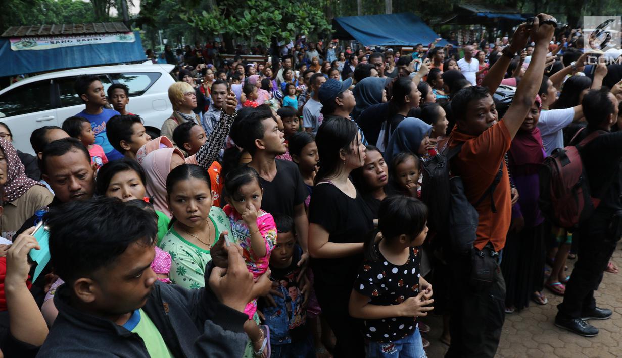 Sejumlah warga saat melihat pemakaman Julia Perez di Taman Pemakaman Umum Pondok Ranggon, Jakarta Timur, Sabtu (10/6). Jupe menghembuskan napas terakhir di RSCM, pada Sabtu 10 Juni 2017. (Liputan6.com/Herman Zakharia)