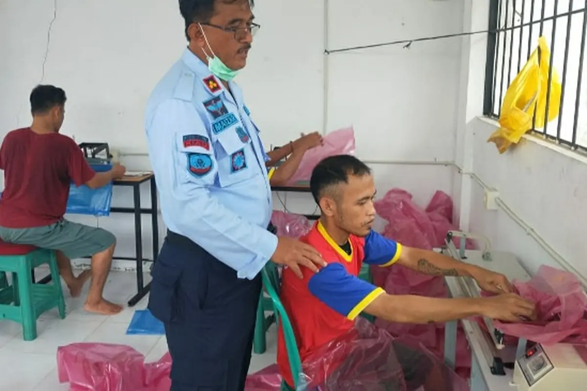 Kepala Lapas Pekanbaru melihat seorang warga binaan tengah membuat jas hujan.