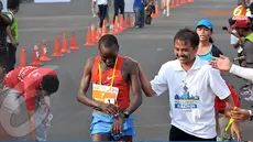 Menteri Pemuda dan Olahraga, Roy Suryo tampak memberikan selamat pada pelari Kenya William Chebor karena menjadi pelari pertama yang mencapai garis finish. (Liputan6.com/Andrian M. Tunay)