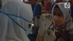Petugas medis menyiapkan vaksin booster untuk warga di Gor Ciracas, Jakarta, Sabtu (19/3/2022). Vaksin booster diberikan kepada warga lanjut usia dan masyarakat berisiko tinggi tertular Covid-19. (merdeka.com/Imam Buhori)