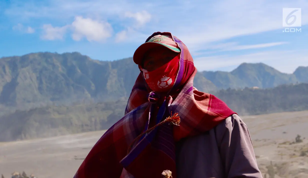 Seekor joki kuda menutup wajahnya dengan kain sarung untuk menghindari debu di Taman Nasional Bromo Tengger Semeru, Jawa Timur, Sabtu (4/11). Penduduk sekitar menyediakan jasa penyewaan kuda untuk wisatawan. (Liputan6.com/Fery Pradolo)