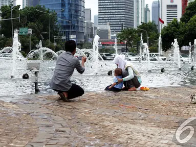 Sejumlah keluarga berfoto bersama di Bundaran Hotel Indonesia (HI), Jakarta, Kamis (1/1/2015). (Liputan6.com/Faizal Fanani)