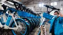 Seorang staf menempatkan sepeda listrik untuk layanan berbagi kendaraan ke dalam truk di sebuah gudang di Distrik Fancheng di Kota Xiangyang, Provinsi Hubei, China tengah (24/4/2020). (Xinhua/Xie Jianfei)