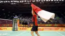 Liliyana Natsir merayakan kemenangan meraih medali emas Olimpiade Rio 2016  pada cabang bulutangkis dengan mengibarkan bendera Merah-Putih di di Stadion Riocentro, Rio de Janeiro, (17/8/2016). (REUTERS/Mike Blake) 
