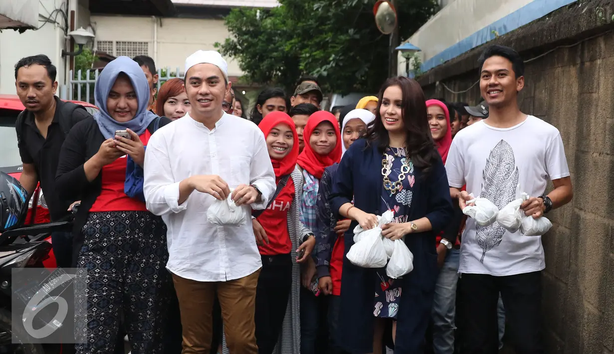 Vokalis Band Geisha Momo membagikan takjil ke pengendara yang melintas di kawasan Perdatam, Jakarta, Rabu (22/6). Memperingati bulan Ramadan Band Geisha dan Fansnya "My Geisha" membagi - bagi Takjil kepada pengendara. (Liputan6.com/Herman Zakharia)