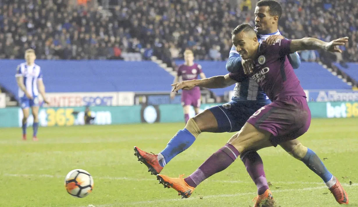 Aksi pemain Manchester City, Danilo (kanan) berusaha melewati adangan pemain Wigan, Nathan Byrne pada laga babak kelima Piala FA di DW Stadium, Wigan, (19/2/2018). Manchester City kalah 0-1.  (AP/Rui Vieira)