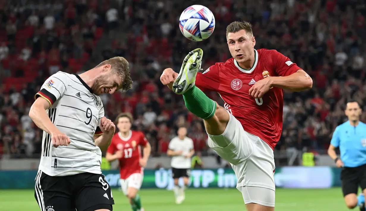 Penyerang Jerman, Timo Werner berebut bola dengan bek Hungaria, Willi Orban pada pertandingan grup A3 UEFA Nations League di Puskas Arena di Budapest, Minggu (12/6/2022). Hasil imbang ini membuat Jerman menduduki tempat ketiga klasemen grup dengan tiga poin, sedangkan Hungaria mengumpulkan empat poin. (AFP/Attila Kisbenedek)