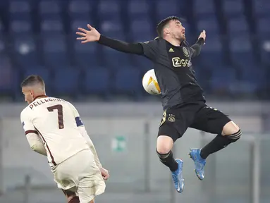 Gelandang AS Roma, Lorenzo Pellegrini dan bek  Ajax Amsterdam, Nicolas Tagliafico bersaing pada leg kedua perempat final Liga Europa di Olimpico, Jumat (16/4/2021) dini hari WIB. AS Roma melaju ke semifinal Liga Europa musim ini setelah bermain imbang 1-1 lawan Ajax. (AP Photo/Alessandra Tarantino)