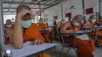 Sejumlah Biksu Buddha memakai masker untuk membantu melindungi diri dari virus corona, mengikuti tes bahasa Pali liturgi di Wat Molilokayaram di Bangkok, Thailand, Kamis (20/1/2022). (AP Photo/Sakchai Lalit)