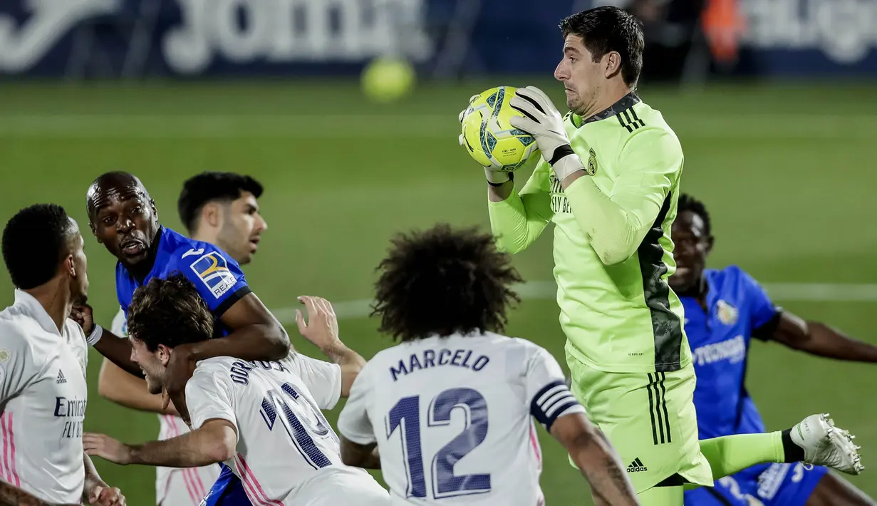 Kiper Real Madrid, Thibaut Courtois, menangkap bola saat melawan Getafe pada laga Liga Spanyol di Stadion Alfonso Perez, Senin (19/4/2021). Kedua tim bermain imbang 0-0. (AP Photo/Manu Fernandez)