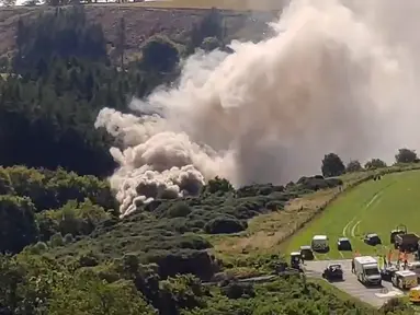 Gambar yang diambil dari rekaman video menunjukkan asap mengepul dari tempat kecelakaan kereta api dekat Stonehaven di timur laut Skotlandia (12/8/2020). Kecelakaan yang terjadi di tengah hujan lebat dan tanah longsor. (AFP/STV NEWS / ESN/Chris Harvey)