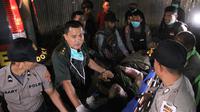 Polisi dan tim medis membawa seorang anggota Brimob yang tertembak saat kontak tembak dengan Kelompok Kriminal Bersenjata (KKB) di Nduga, Papua, Rabu (5/12). Korban saat ini mendapat perawatan medis di sebuah rumah sakit di Wamena. (ANYONG/AFP)