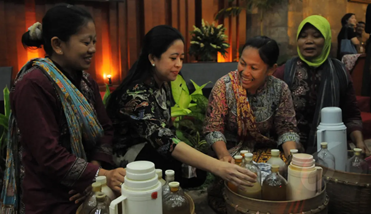 Menko PMK Puan Maharani berbincang dengan para penjual jamu keliling di sela-sela  acara minum jamu bersama di gedung Kementerian Perindustrian, Jakarta Jumat (16/1/2015). (Liputan6.com/Herman Zakharia)