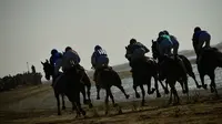 Para peserta saling balap saat mengikuti lomba pacuan kuda pantai tahunan di Sanlucar de Barrameda, dekat Cadiz, Spanyol (17/8). (AFP Photo/Cristina Quicler)