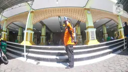 Petugas menyemprotkan cairan disinfektan di Masjid Kauman Semarang,  Jawa Tengah, Senin (16/3/2020). Penyemprotan dilakukan untuk mencegah penyebaran virus corona COVID-19. (Liputan6.com/Gholib)