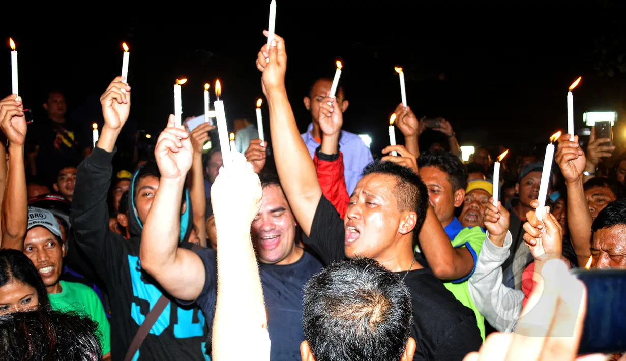 Pasca-eksekusi mati, empat rekan duo Bali Nine, Andrew Chan dan Myuran Sukumaran terlihat menyalakan lilin saat menggelar doa bersama di depan pagar Dermaga Wijaya Pura, Cilacap, Jateng, Rabu (29/4/2015) dini hari. (Liputan6.com/Yoppy Renato)