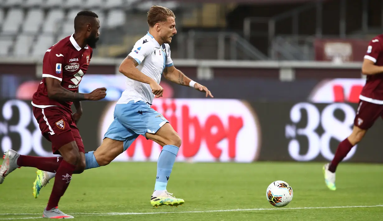 Gelandang Lazio, Ciro Immobile, berusaha melewati pemain Torino pada laga lanjutan Serie A pekan ke-29 di Stadion Olimpico Grande Torino, Rabu (1/7/2020) dini hari WIB. Lazio menang 2-1 atas Torino. (AFP/Isabella Bonotto)