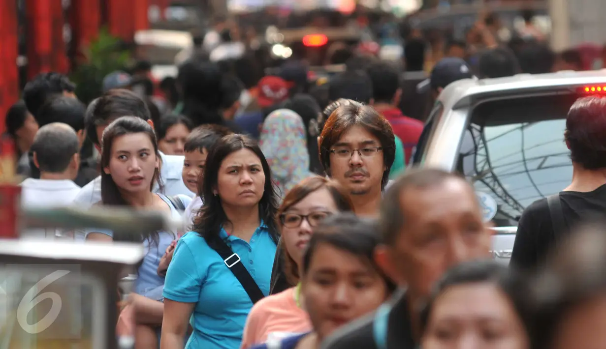 Warga memadati kawasan perbelanjaan Pasar Baru, Jakarta, Minggu (26/6). Menjelang lebaran sejumlah toko mulai memberikan potongan harga untuk menarik pembeli. (Liputan6.com/Gempur M Surya)