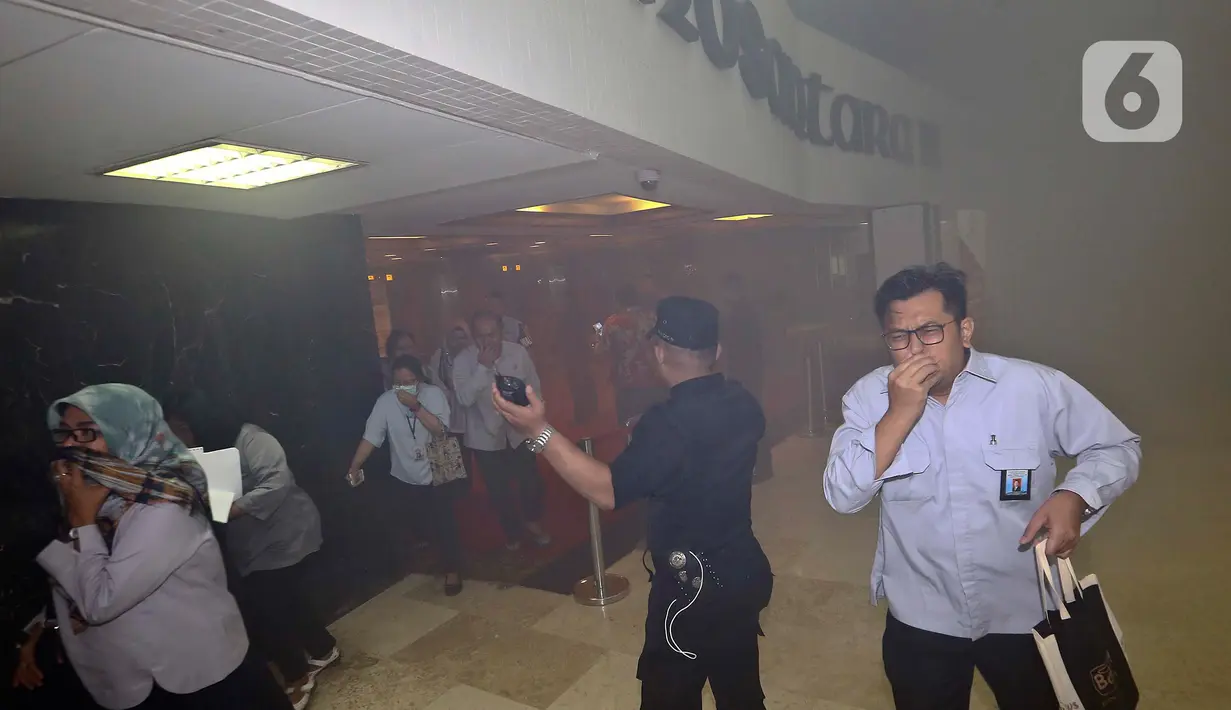 Pegawai berhamburan ke luar ruangan saat kepulan asap putih memenuhi Gedung Nusantara III, Kompleks Parlemen, Senayan, Jakarta, Senin (24/2/2020). Menurut  Sekjen DPR  Indra Iskandar, asap itu bukan dari kebakaran melainkan kerusakan sistem aerosol pada pukul 12.00 WIB. (Liputan6.com/Johan Tallo)