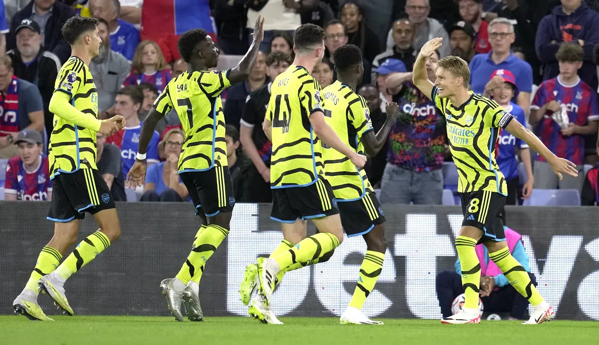 <p>Gelandang Arsenal, Martin Odegaard (kanan) berselebrasi dengan rekan setimnya setelah mencetak gol lewat titik penalti ke gawang Crystal Palace pada pertandingan lanjutan Liga Inggris di Selhurst Park, di London, Inggris, Selasa, 22 Agustus 2023. (AP Photo/Kin Cheung)</p>