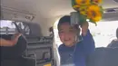 Abimanyu Manggala Nugroho Putro senyum saat ibundanya akan naik mobil. Sedangkan di tangannya memegang bunga dan uang kertas pecahan dua ribu. [Instagram/vickyshu]