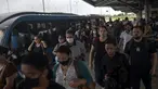 Para komuter berjalan di stasiun BRT Recreio pada hari pertama pencabutan aturan wajib masker di luar ruangan, di Rio de Janeiro, Brasil, Kamis (28/12/2021). Pencabutan aturan wajib masker ini efektif berlaku pada Kamis (28/10) waktu setempat. (MAURO PIMENTEL / AFP)
