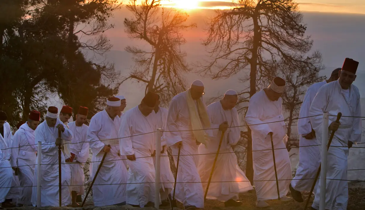 Kaum Samaritan berjalan menuju puncak Gunung Gerizim untuk berdoa dalam perayaan hari Sukkot di Israel (4/10). Mereka adalah sebuah komunitas agama kuno yang memisahkan diri dari agama Yahudi sekitar 2.000 tahun yang lalu. (AFP Photo/Jaafar Ashtiyeh)
