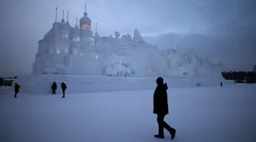 Sejumlah Pengunjung berjalan ditempat wahana es yang berda di kota utara Harbin, provinsi Heilongjiang , Cina, (5/1). Bangunan es yang dibuat menyerupai Istana dengan ukuran yang besar. (REUTERS/Aly Song)