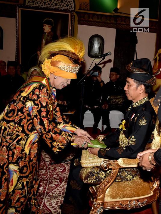 Presiden Joko Widodo saat menjalani prosesi Tepung Tawar di Istana Maimoon, Minggu (6/10). Prosesi ini melibatkan 4 unsur perwakilan, yaitu Sultan Deli, perwakilan Raja-raja Nusantara, Gubernur Sumut, dan perwakilan Alim ulama. (Liputan6.com/HO/Biropers)