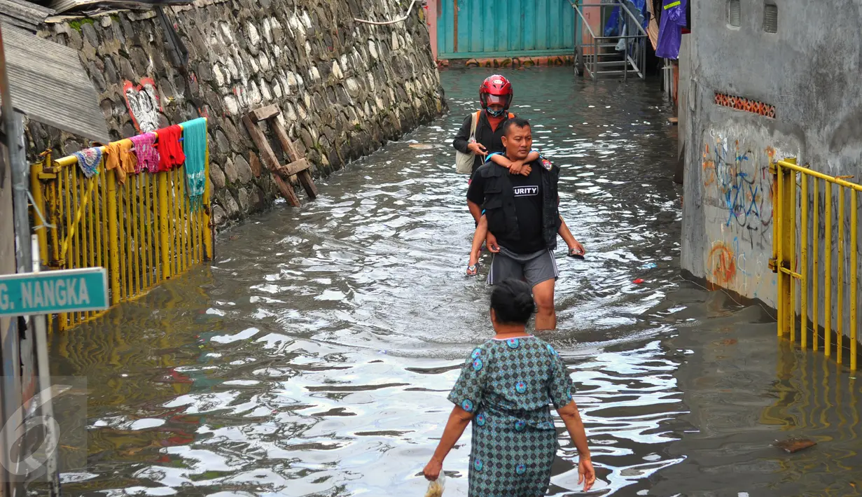Warga melawati jalanan yang banjir di kawasan Jakarta Barat, Jumat (26/2). Banjir terjadi juga dikarenakan kali Daan Mogot yang  tak kunjung surut. (Liputan6.com/Faisal R Syam)