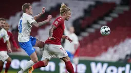 Bek Islandia, Ari Skulason (kiri), berebut bola dengan gelandang Denmark, Daniel Wass, dalam laga UEFA Nations League Grup A2 di Parken Stadium, Copenhagen, Denmark, Senin (16/11/2020) dini hari WIB. Islandia kalah 1-2 dari Denmark. (AFP/Liselotte Sabroe/Ritzau Scanpix).