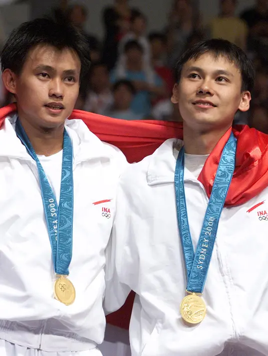 Pemain badminton Indonesia Candra Wijaya (kiri) dan Tony Gunawan mengibarkan bendera usai mengalahkan pemain badminton Korea Selatan Lee Dong-Soo dan Yoo Yong-Sung pada laga final ganda putra Olimpiade Sydney 2000 di Sydney Olympic Park Pavillions, Australia, 21 September 2000. (ROBYN BECK/AFP)