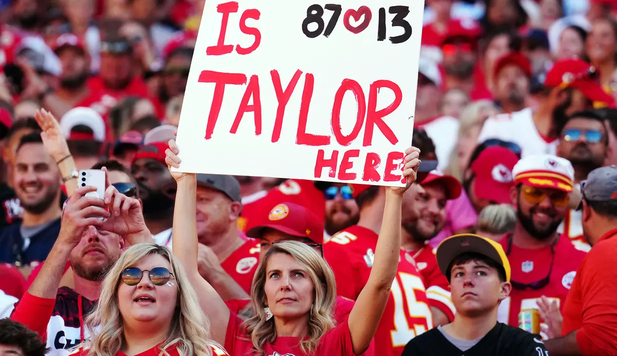 Seorang fans Kansas City Chief mengangkat poster yang bertuliskan "apakah Taylor ada di sini" saat laga National Football League (NFL) antara Kansas City Chiefs melawan Chicago Bears di Arrowhead Stadium, Kansas, Misouri, Amerika Serikat pada Minggu (24/09/2023) waktu setempat. (AFP/Getty Images/Jason Hanna)